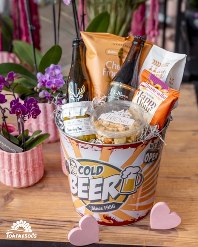 Panier garni gourmand avec bières, snacks salés et douceurs, présenté comme idée cadeau Saint-Valentin.